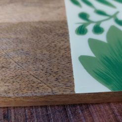 Handgeschilderde houten snijplank met blauw-witte vissenprint, gemaakt van duurzaam mangohout. Multifunctioneel ontwerp voor snijden en serveren, met natuurlijke ophanglus. Afmetingen 44 x 26.5 cm, 2 cm dik. Handgemaakt in India, ondersteunt vakmanschap en eerlijke lonen