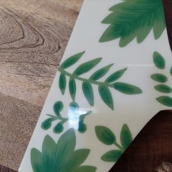 Handgeschilderde houten snijplank met blauw-witte vissenprint, gemaakt van duurzaam mangohout. Multifunctioneel ontwerp voor snijden en serveren, met natuurlijke ophanglus. Afmetingen 44 x 26.5 cm, 2 cm dik. Handgemaakt in India, ondersteunt vakmanschap en eerlijke lonen