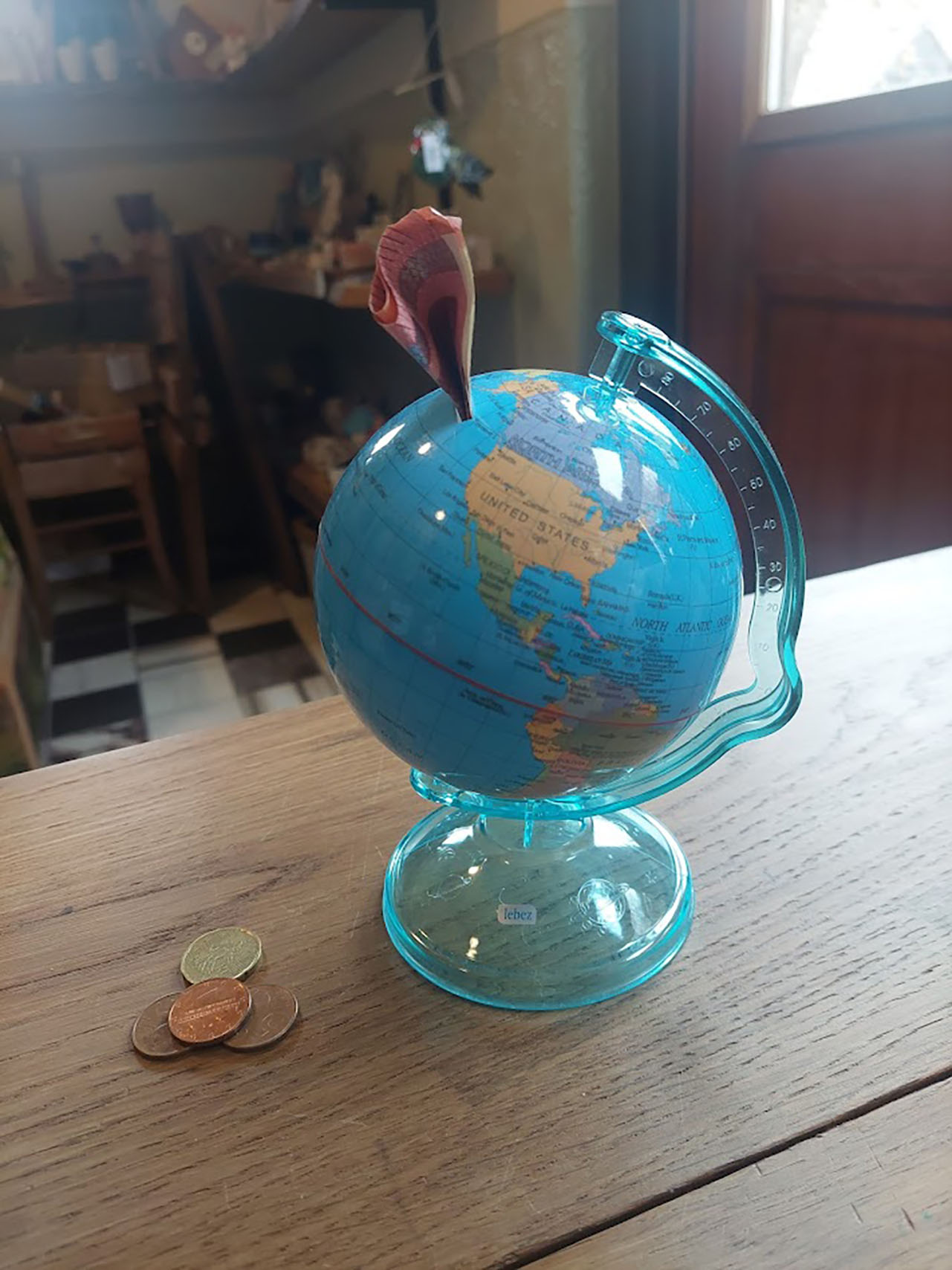 Spaarpot wereldbol van stevig kunststof op standaard met gleuf voor munt- en briefgeld – diameter 10 cm –