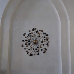 Gouden metalen wandcirkel met schaduweffect door verlichting op de muur